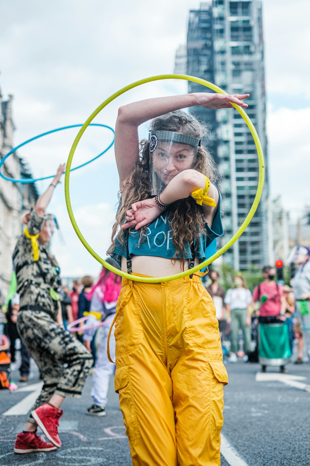 a woman in yellow pants holding a hoop