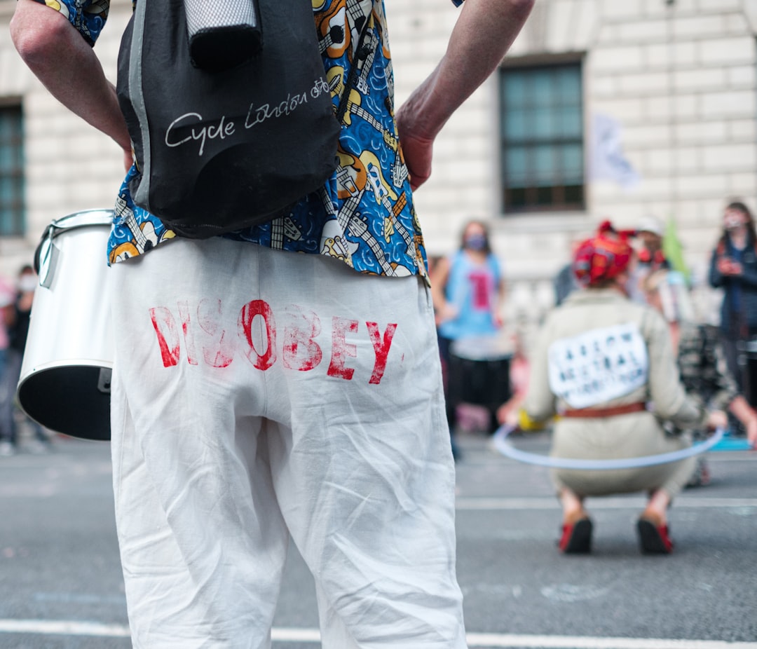 man in black t-shirt and white pants with blue and red scarf