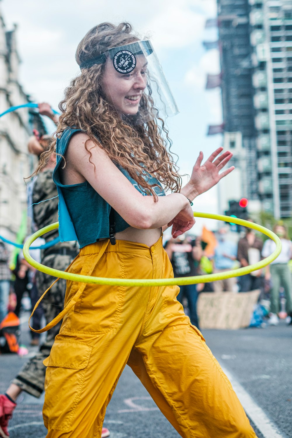 woman in blue tank top and yellow pants holding yellow rope