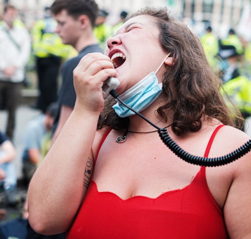 woman in red spaghetti strap top wearing white headphones