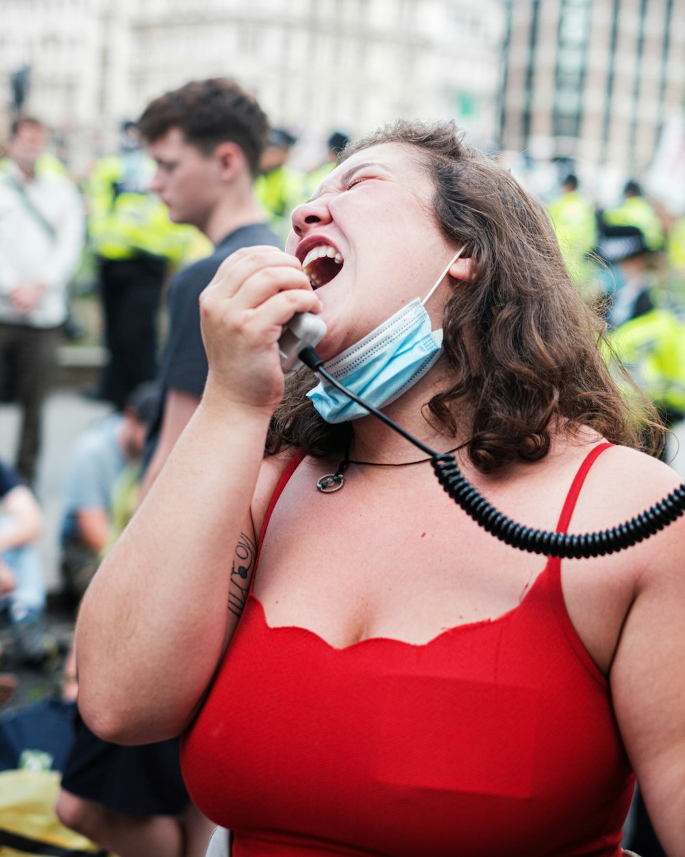 woman in red spaghetti strap top wearing white headphones