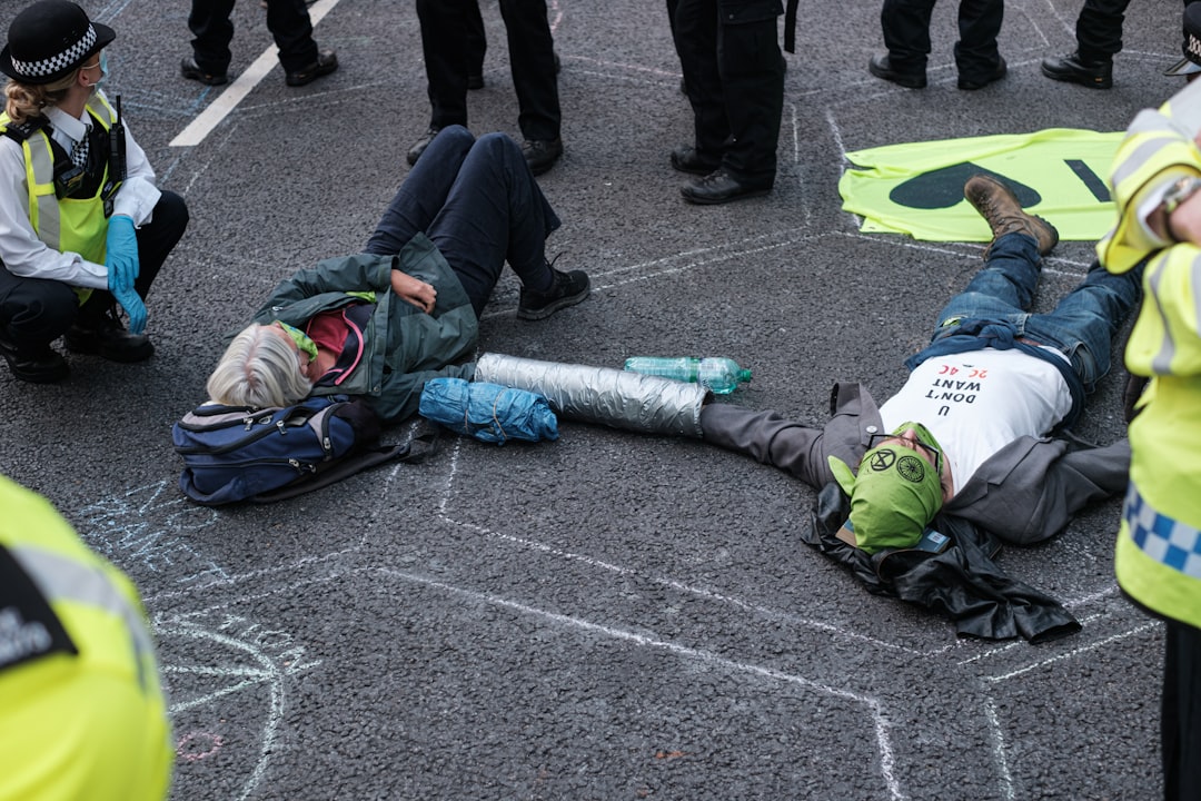 person in green and white jacket lying on gray concrete floor