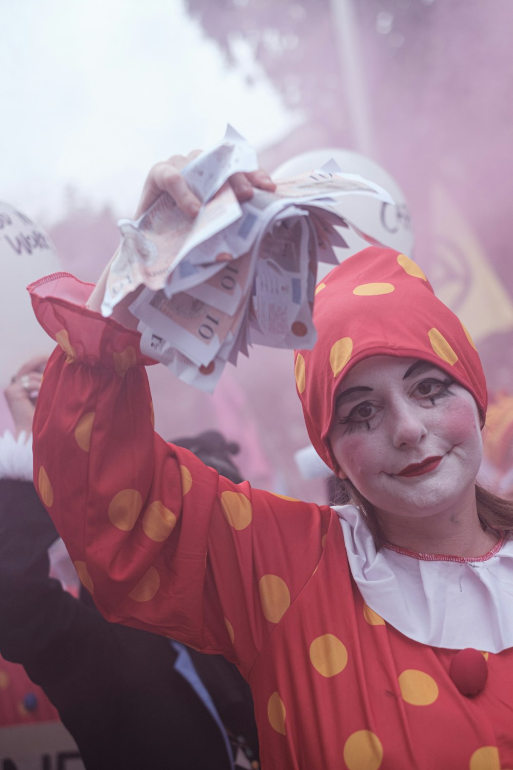 smiling woman in white and red shirt wearing orange and yellow hat