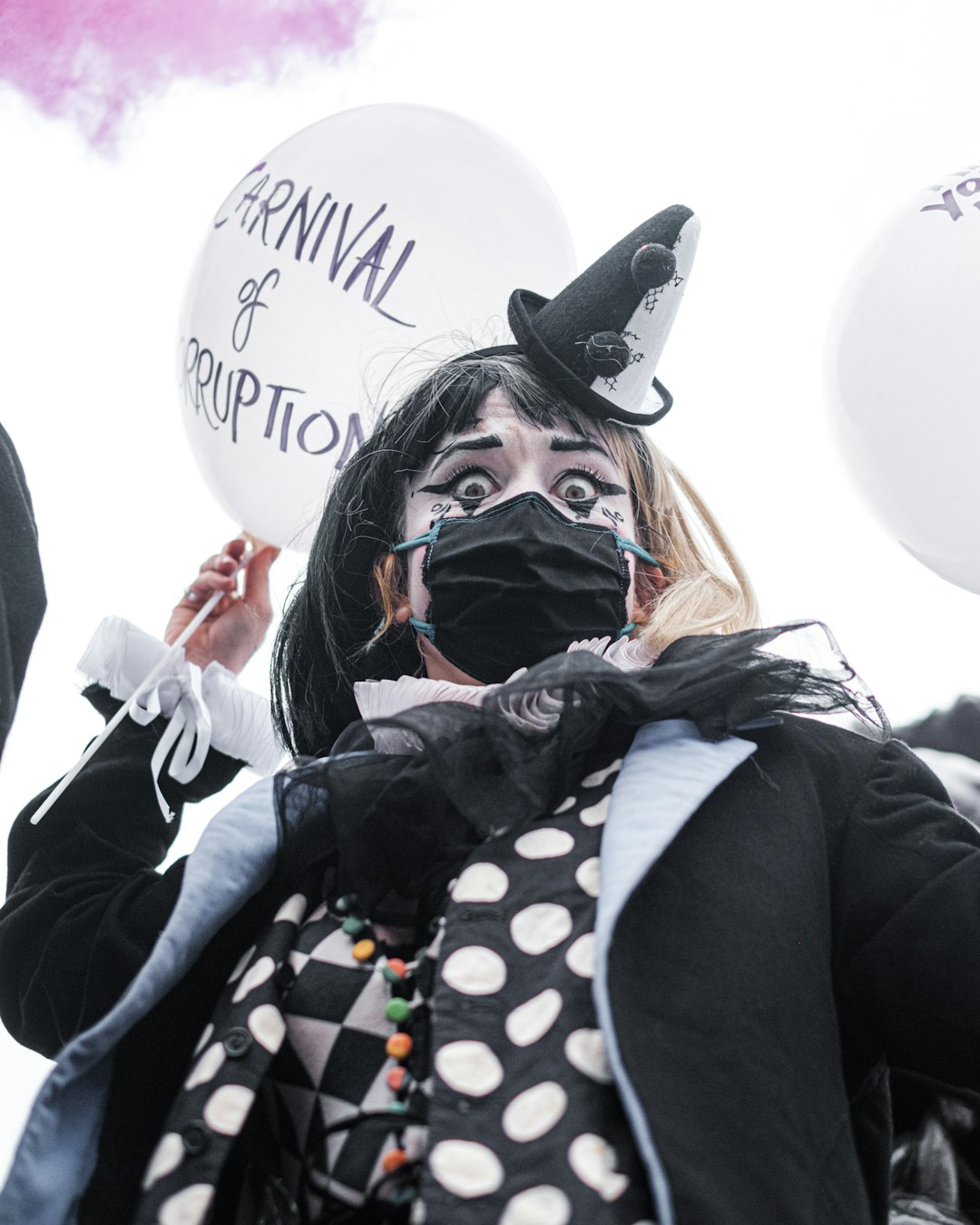 woman in black and white polka dot long sleeve shirt wearing black mask