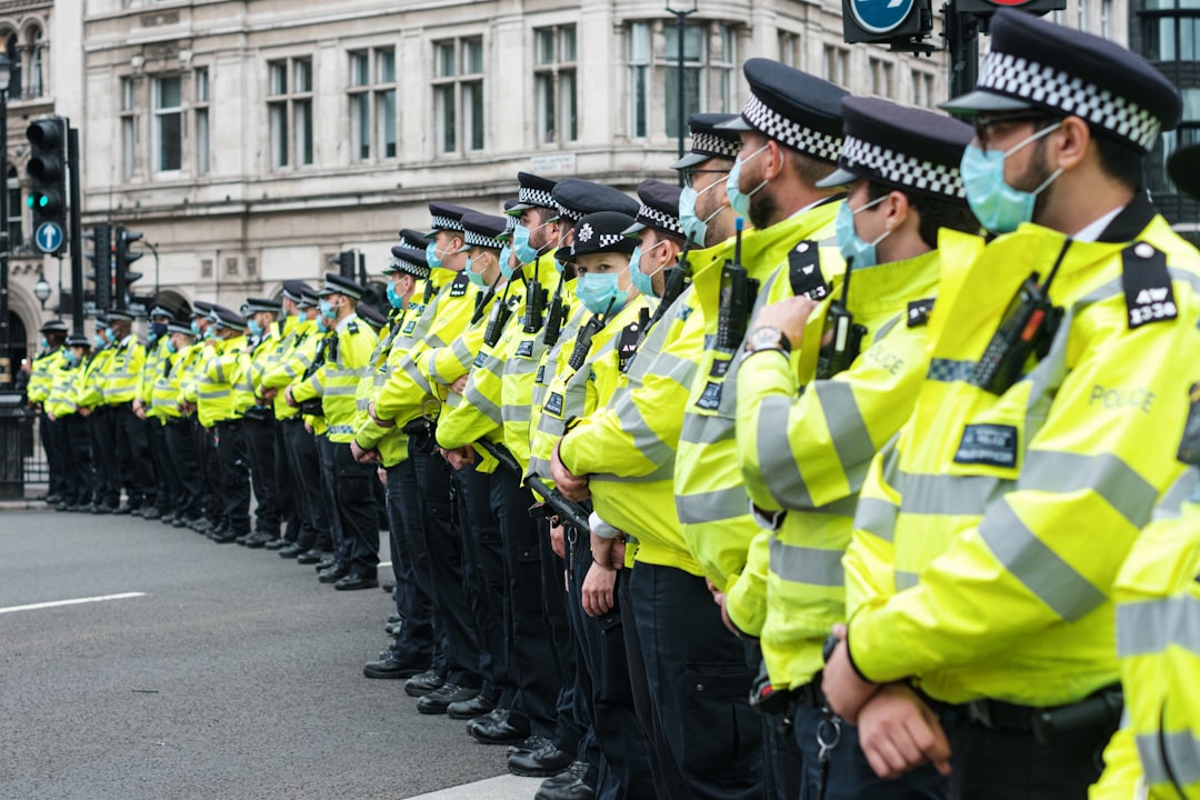 men in green and black uniform standing on road during daytime