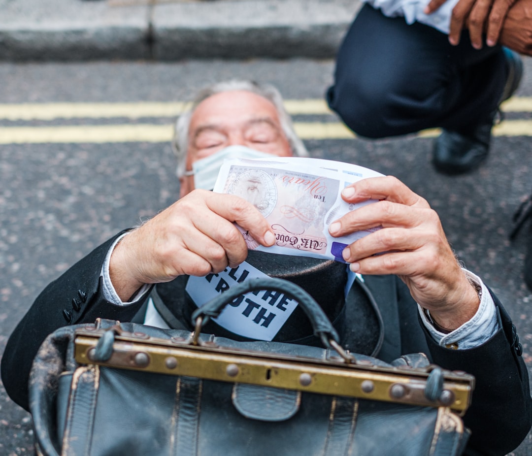 person in black suit holding 20 us dollar bill