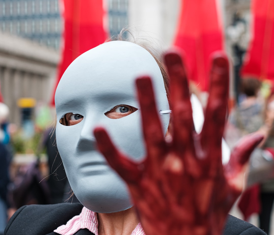 person in white mask with red and white face paint