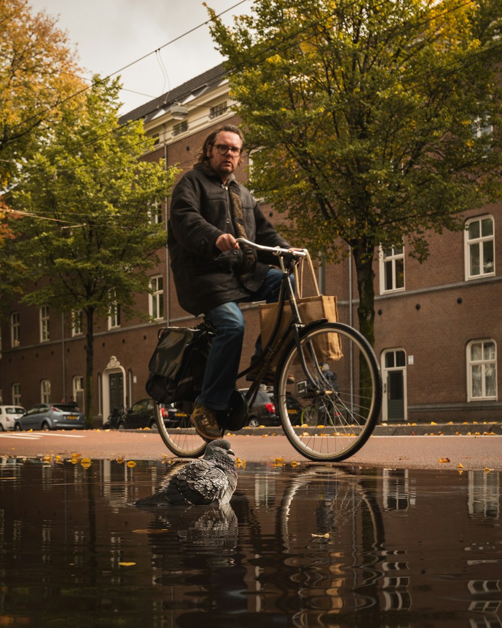man in black jacket riding on bicycle