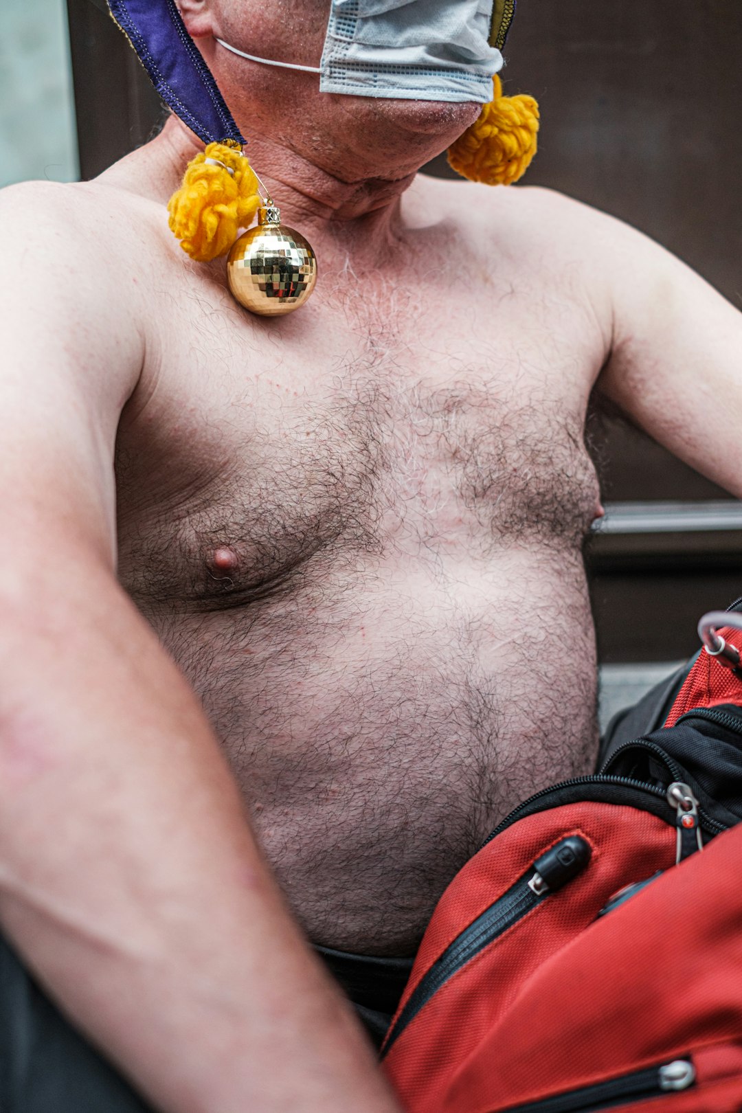 topless man with gold and orange gemstone ring