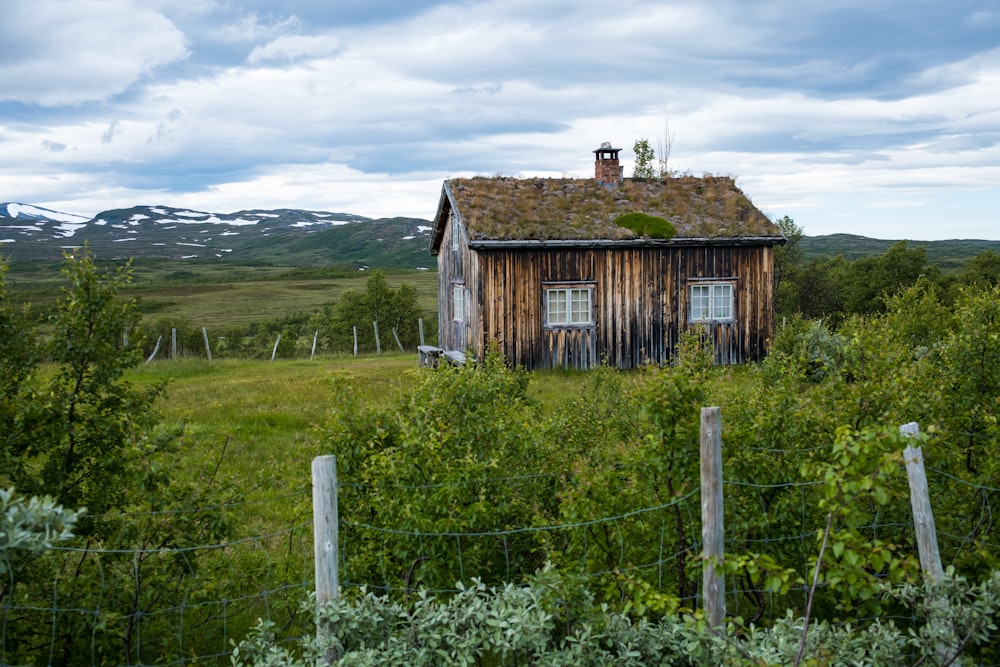 brown wooden house on green grass field during daytime