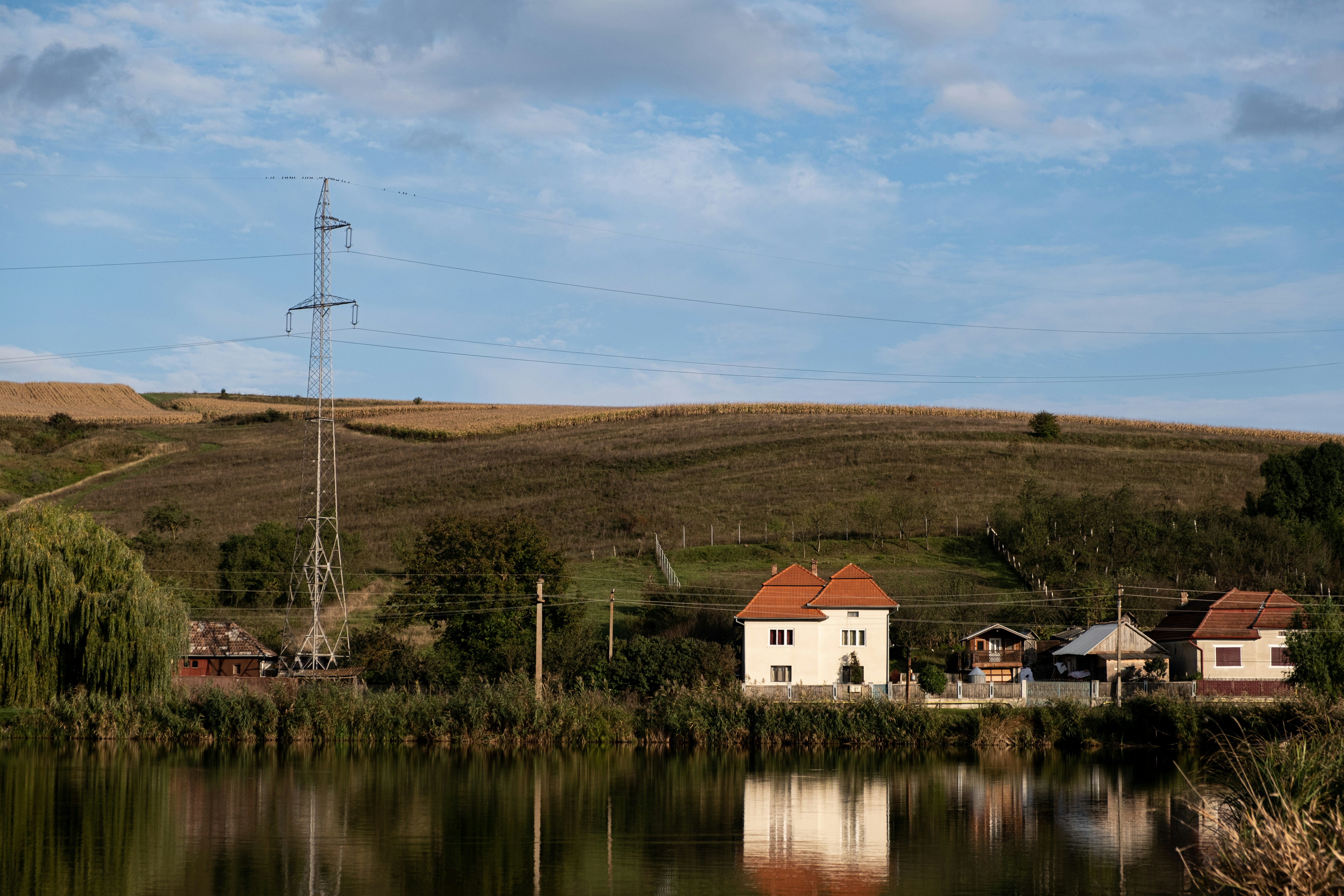 white and brown house near body of water under blue sky during daytime