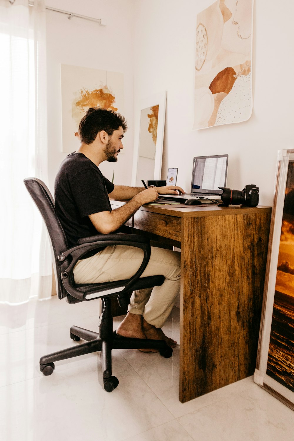 Un hombre sentado en un escritorio trabajando en una computadora portátil