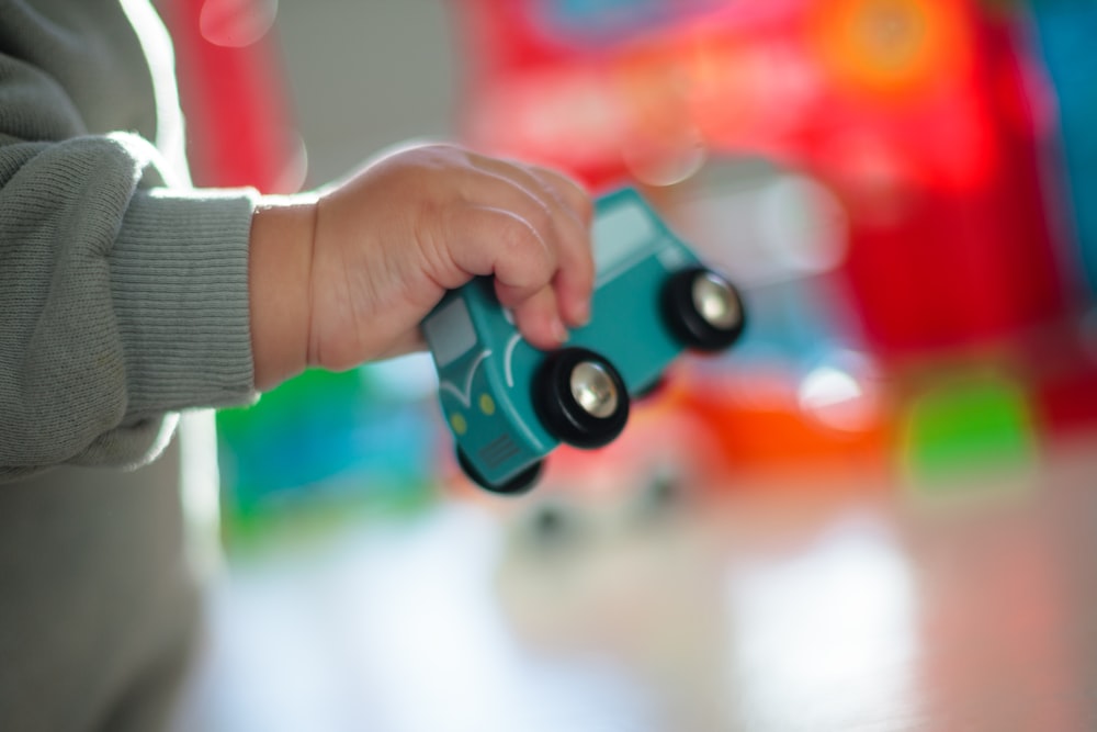 person holding blue and red toy gun