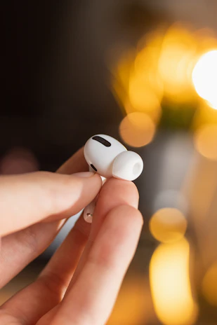Close-up of a wireless earbud with soft lighting highlighting its design.