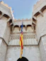 yellow blue and red flag on top of brown concrete building during daytime