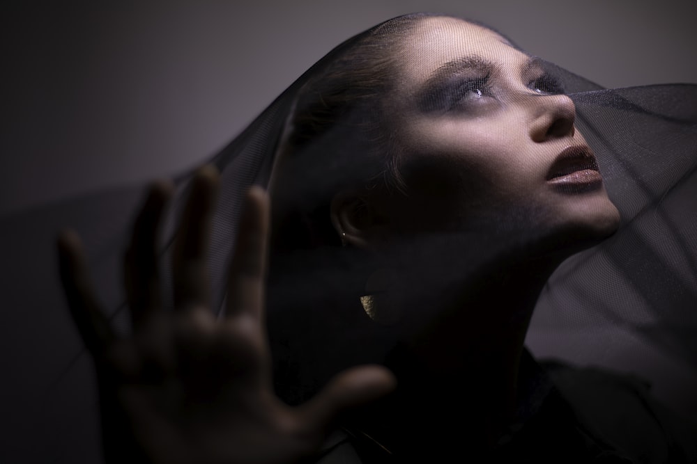 woman in black shirt holding her face