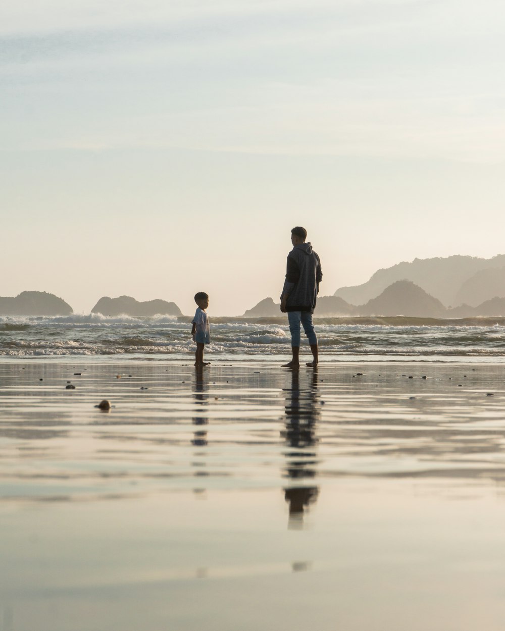 man and woman walking on beach during daytime