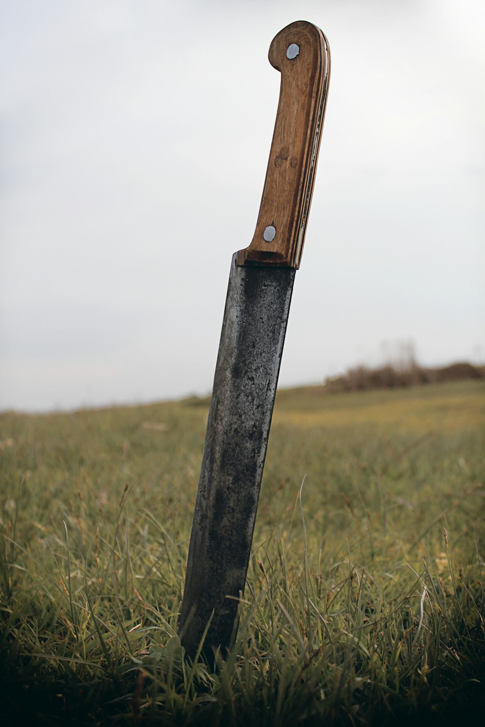 coltello con manico nero sul campo di erba verde durante il giorno