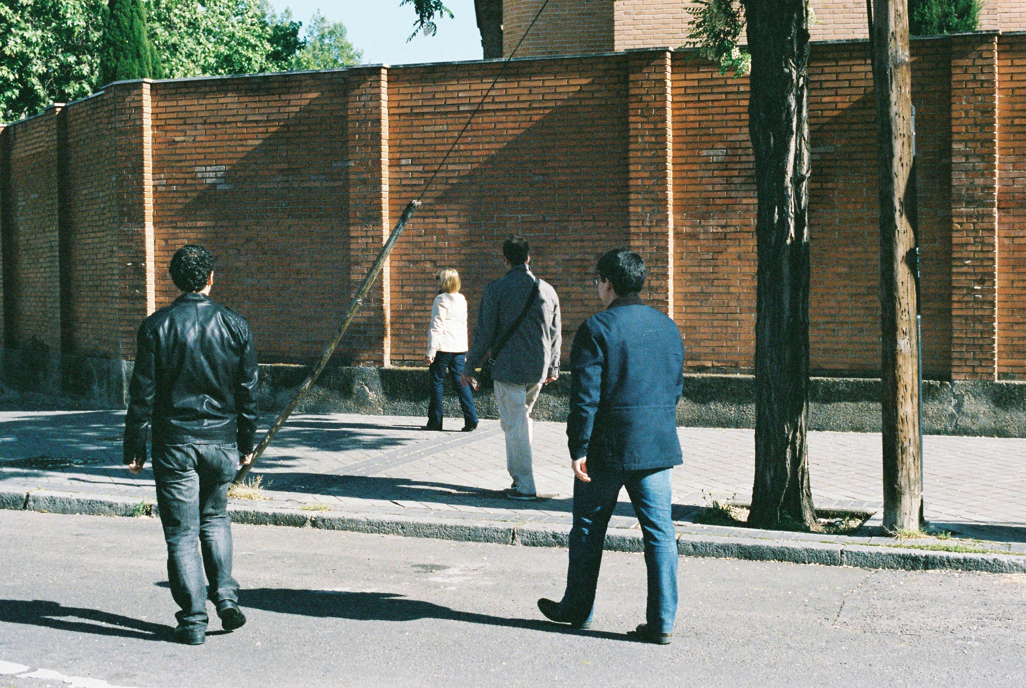 man in gray jacket walking on sidewalk during daytime