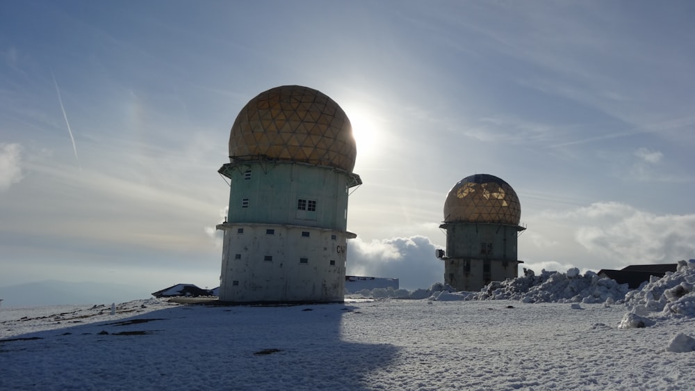 Edificio de cúpula blanca y marrón en un terreno cubierto de nieve durante el día