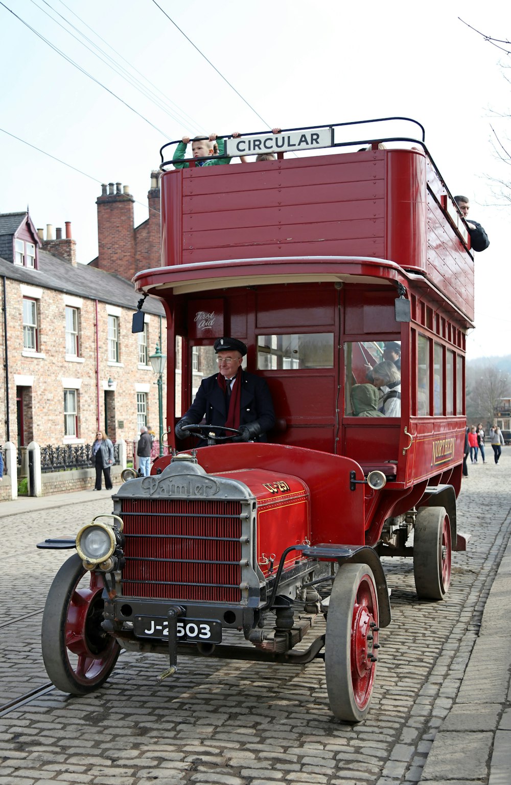 man in black jacket riding red vintage car during daytime