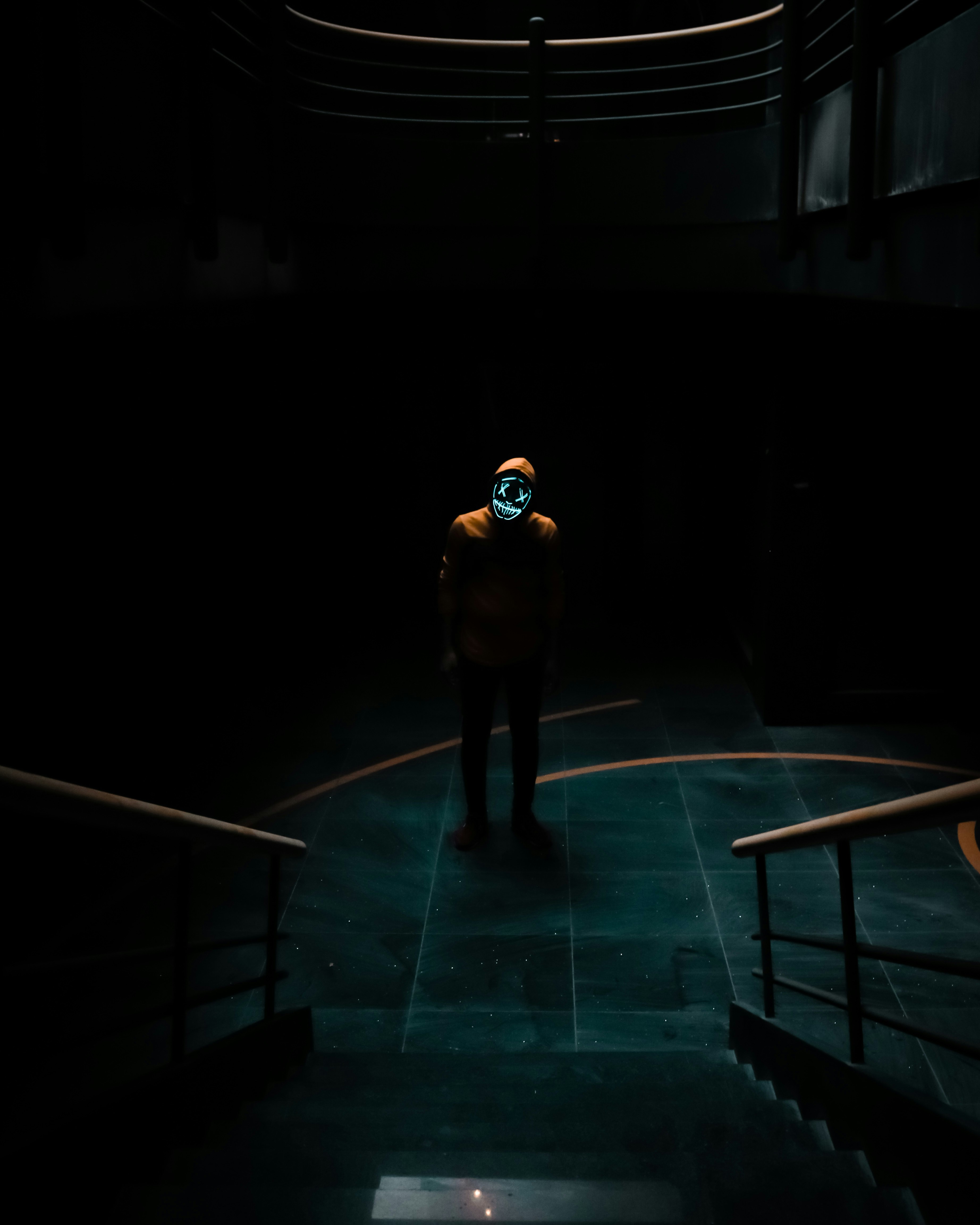 man in black jacket standing on blue floor