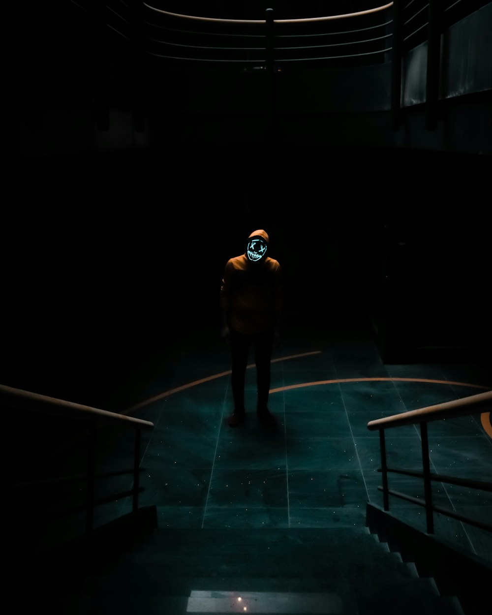 man in black jacket standing on blue floor