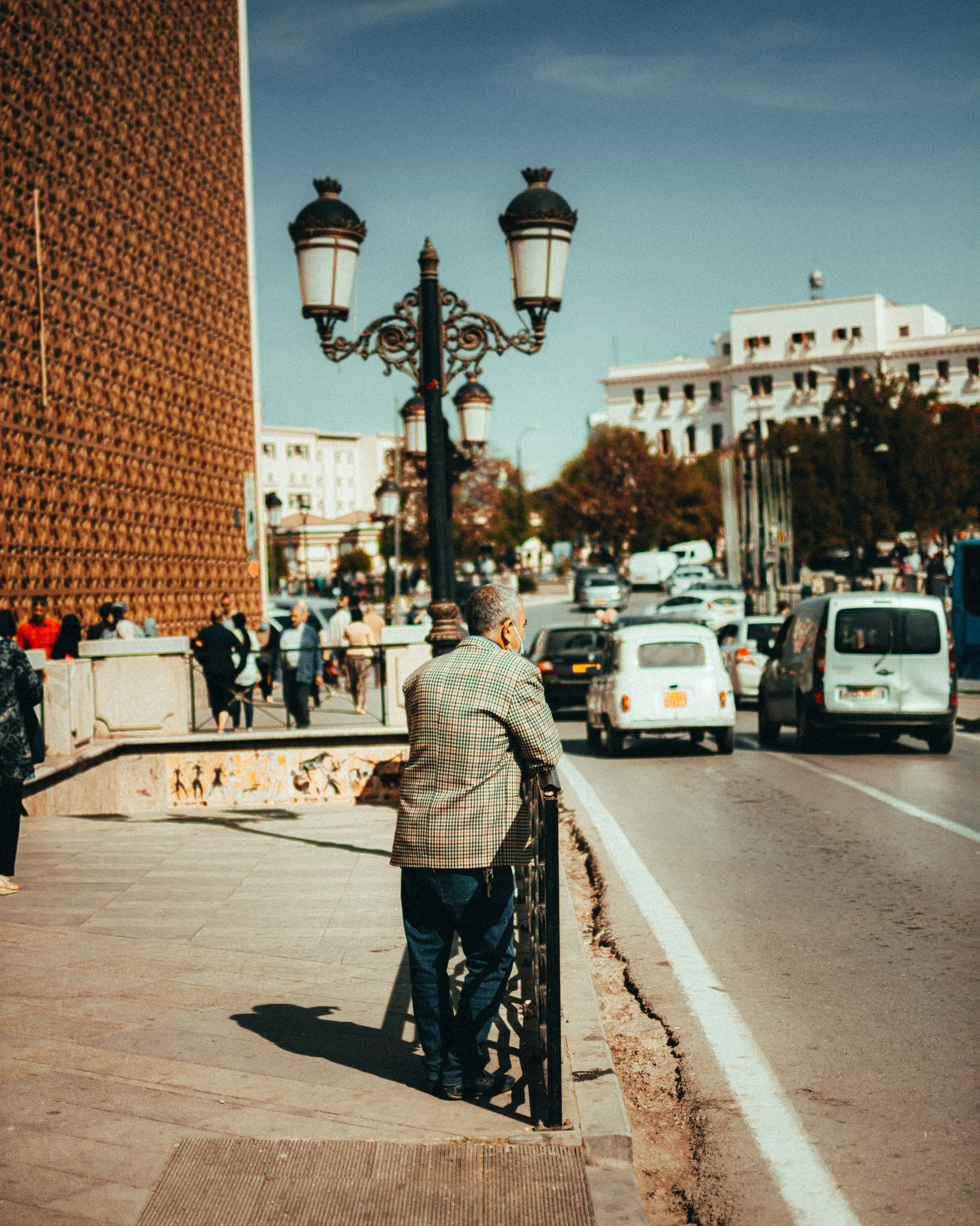 people walking on sidewalk near brown concrete building during daytime