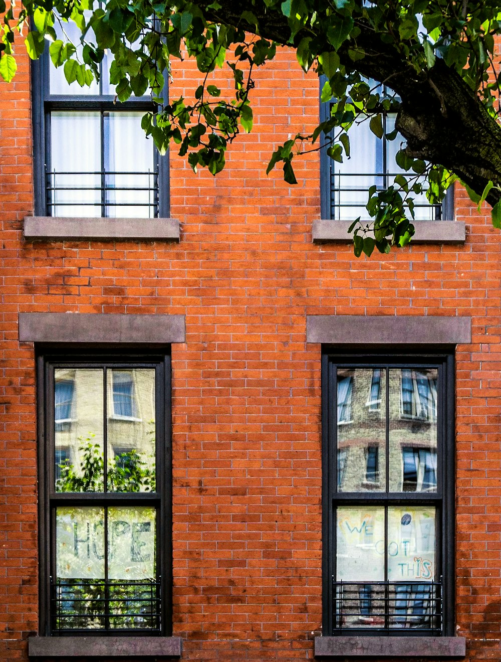 brown brick building with green and white window