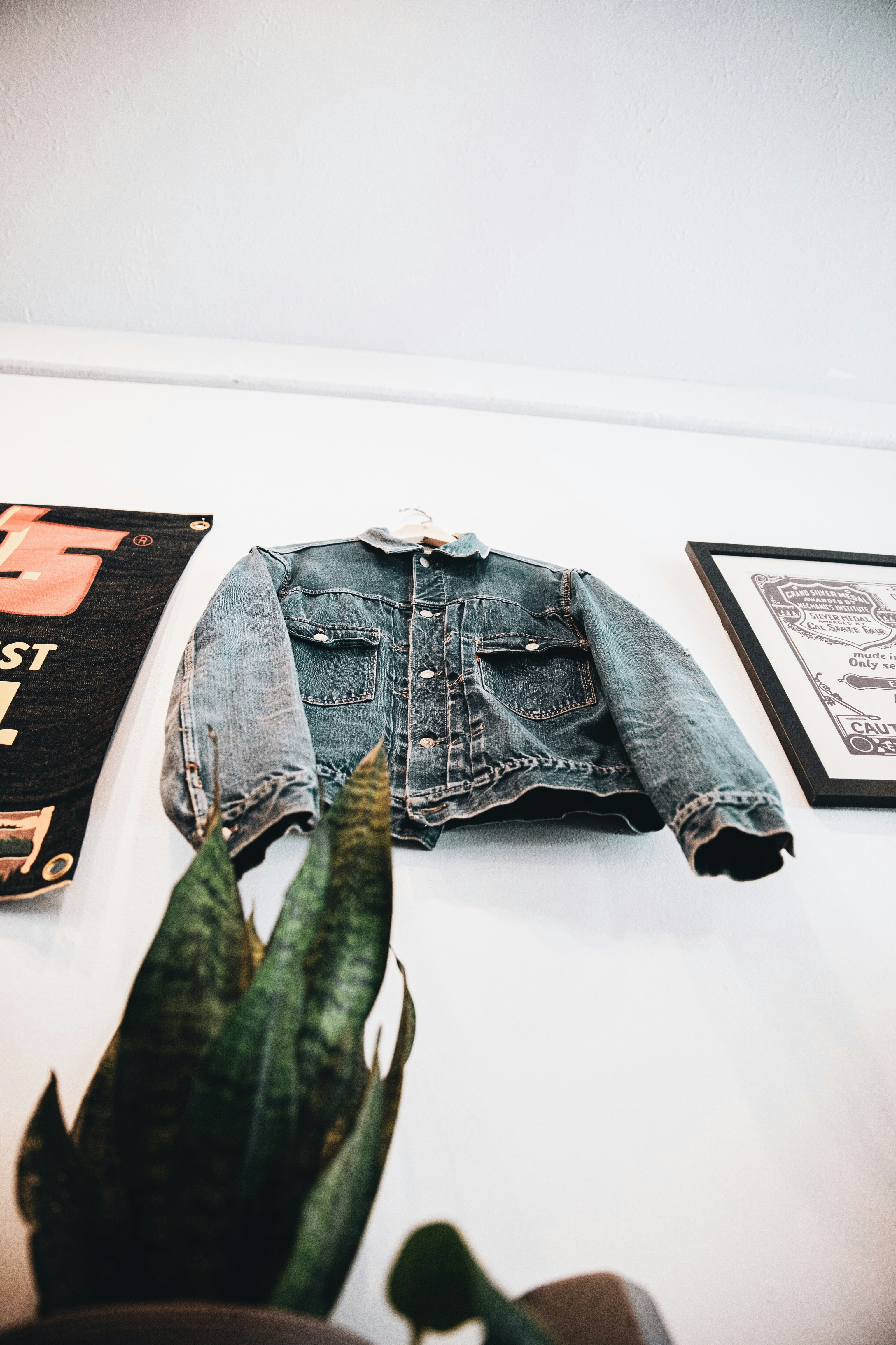 Light blue track jacket on hanger against white wall