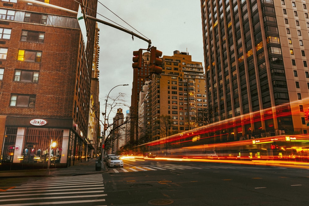 cars on road between high rise buildings during daytime