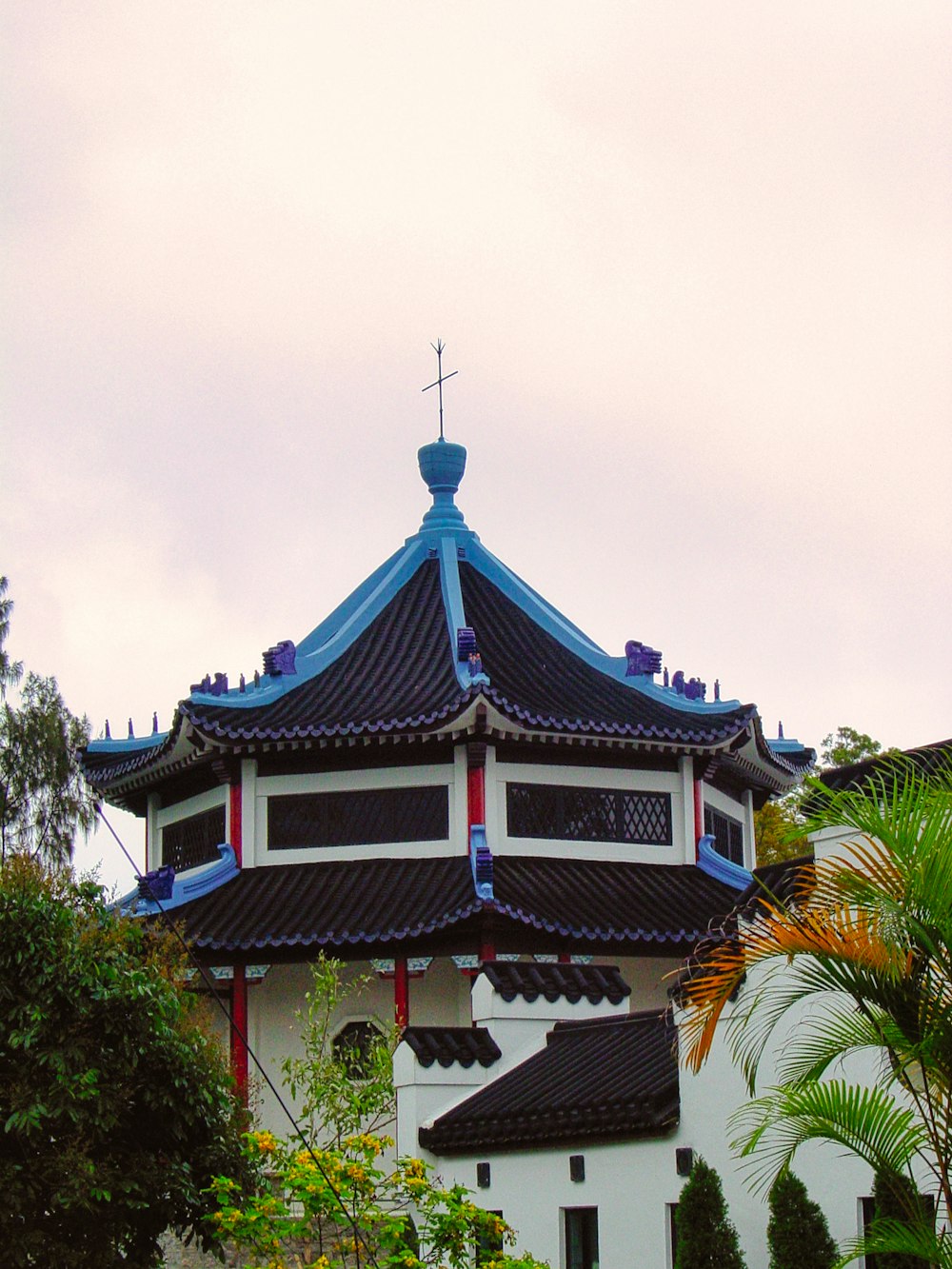 brown and black temple surrounded by green trees under white clouds during daytime