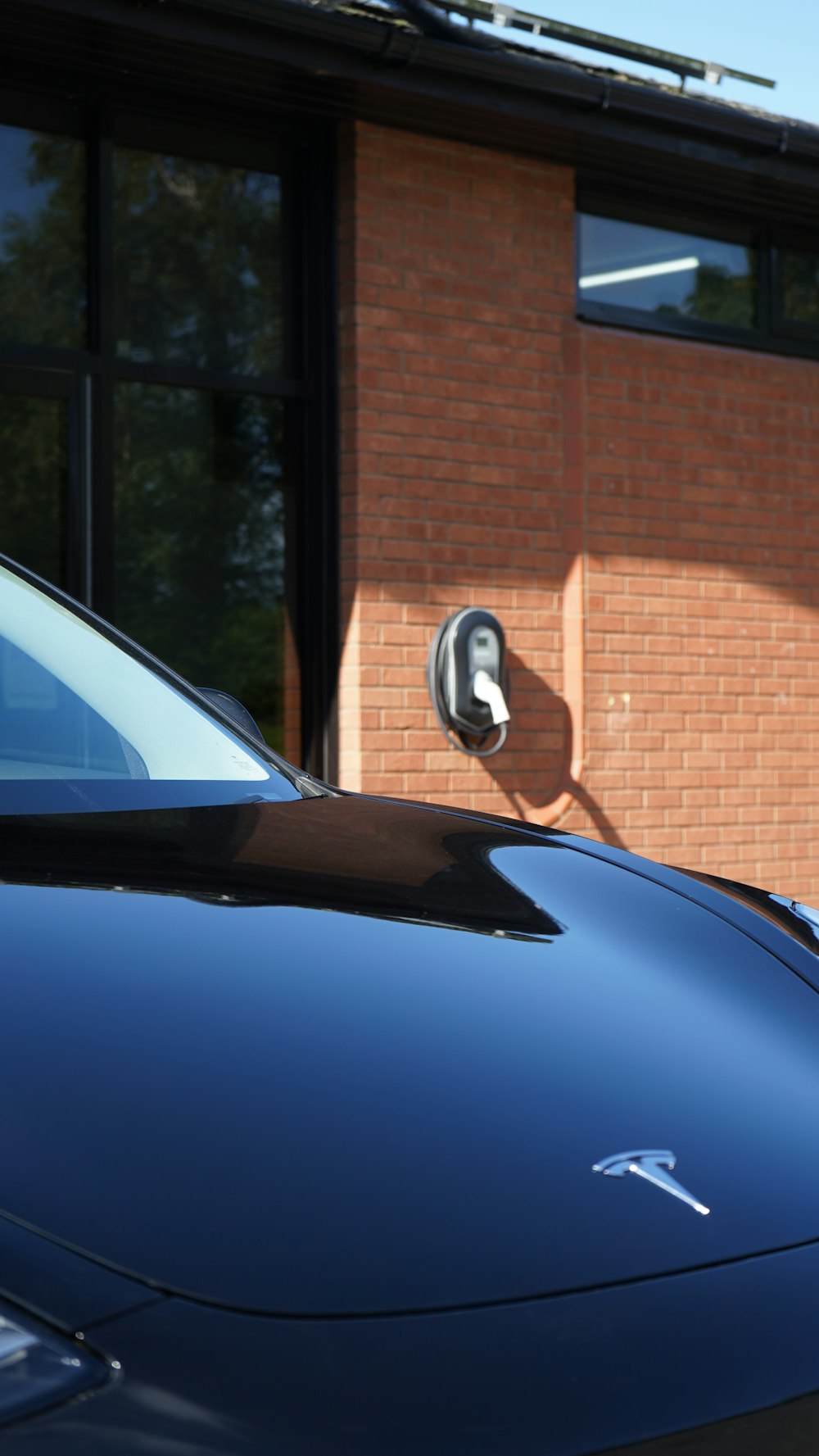 blue car parked near brown brick building