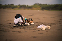 A collection of personalized gifts arranged on a sandy beach backdrop with coastal colors.