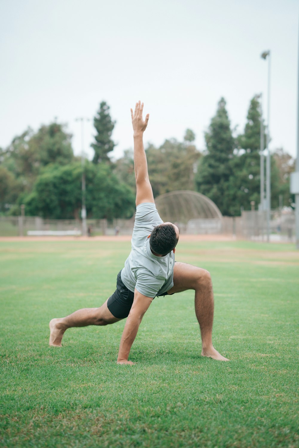 man in black and white t-shirt and black shorts sitting on green grass field during