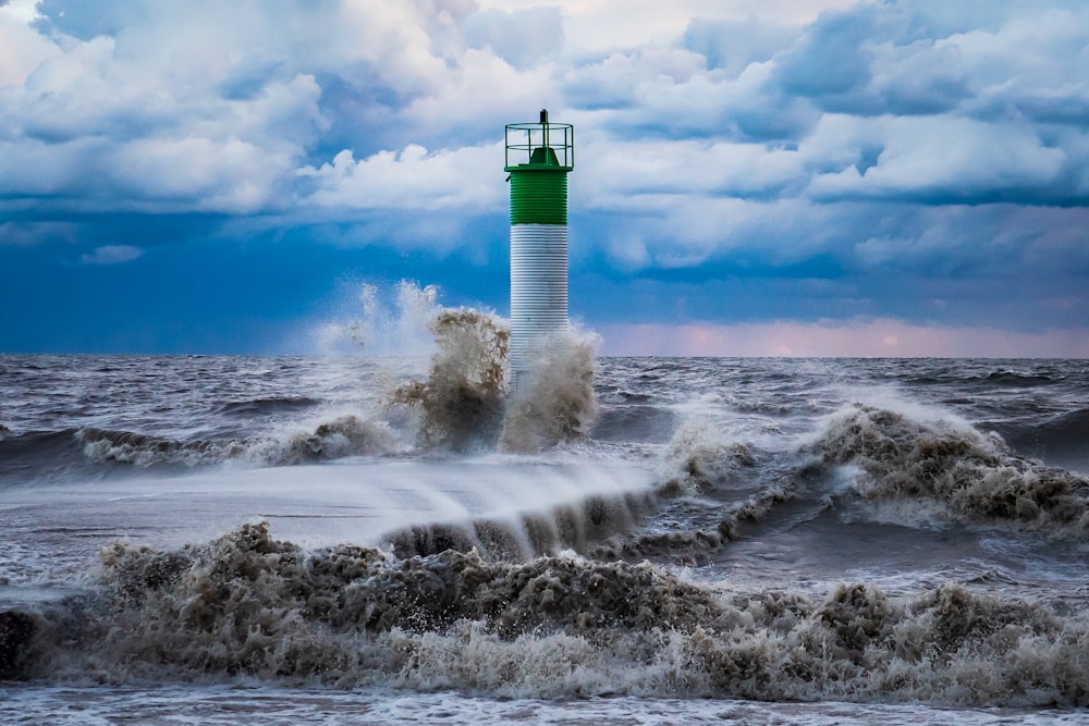 white and black lighthouse on white clouds during daytime