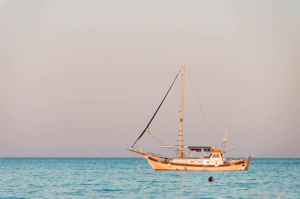 barco branco e marrom no mar durante o dia