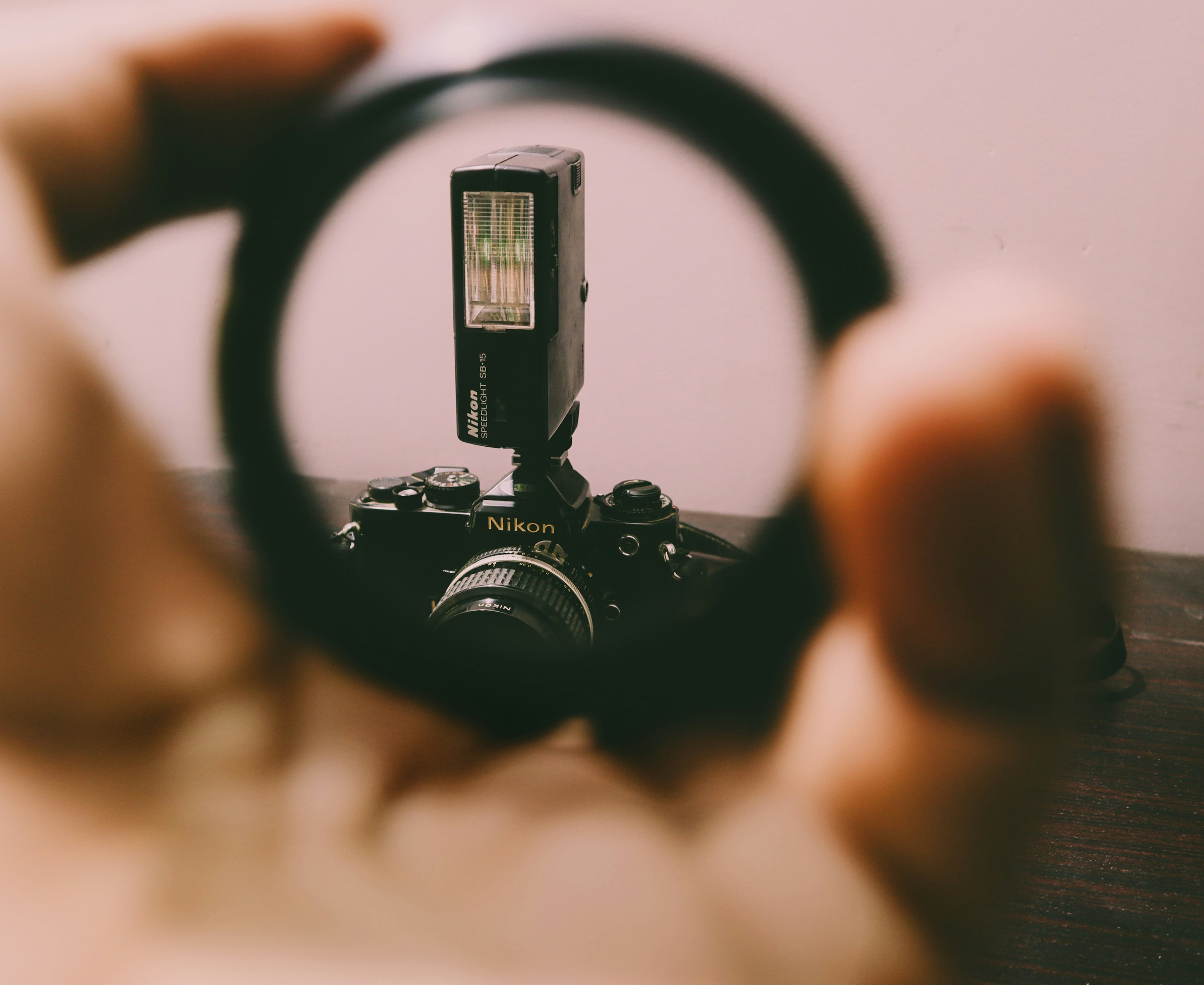 a person holding a camera through a magnifying glass