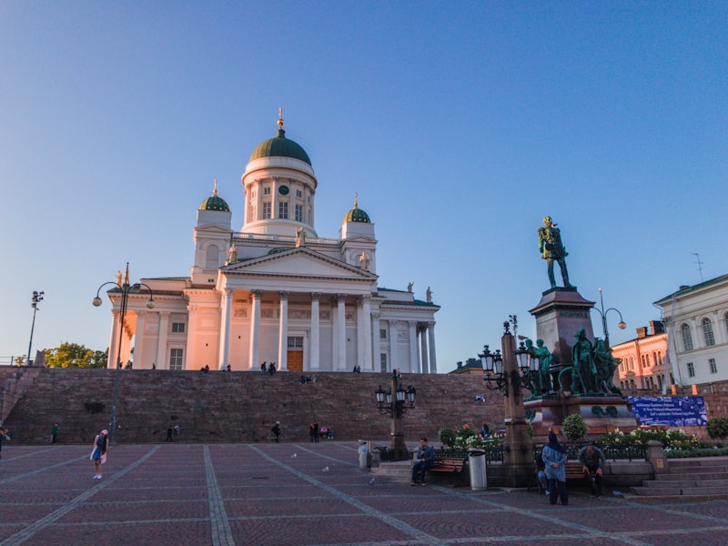 People walking on a sunny Helsinki street near the cathedral