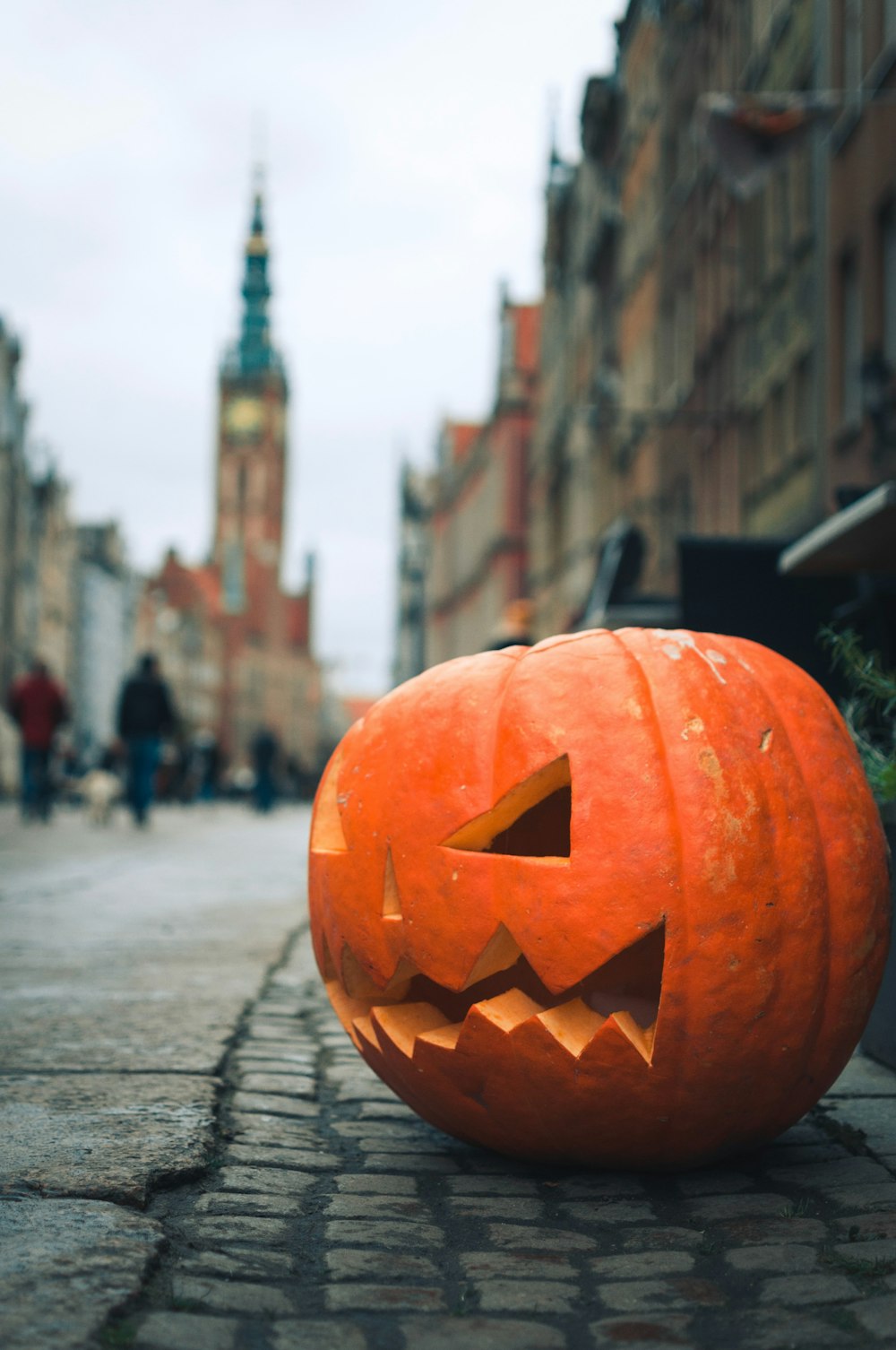 orange jack o lantern on gray pavement during daytime