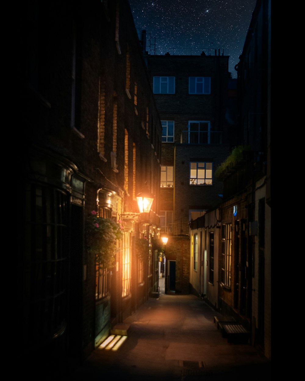 empty street between concrete buildings during night time