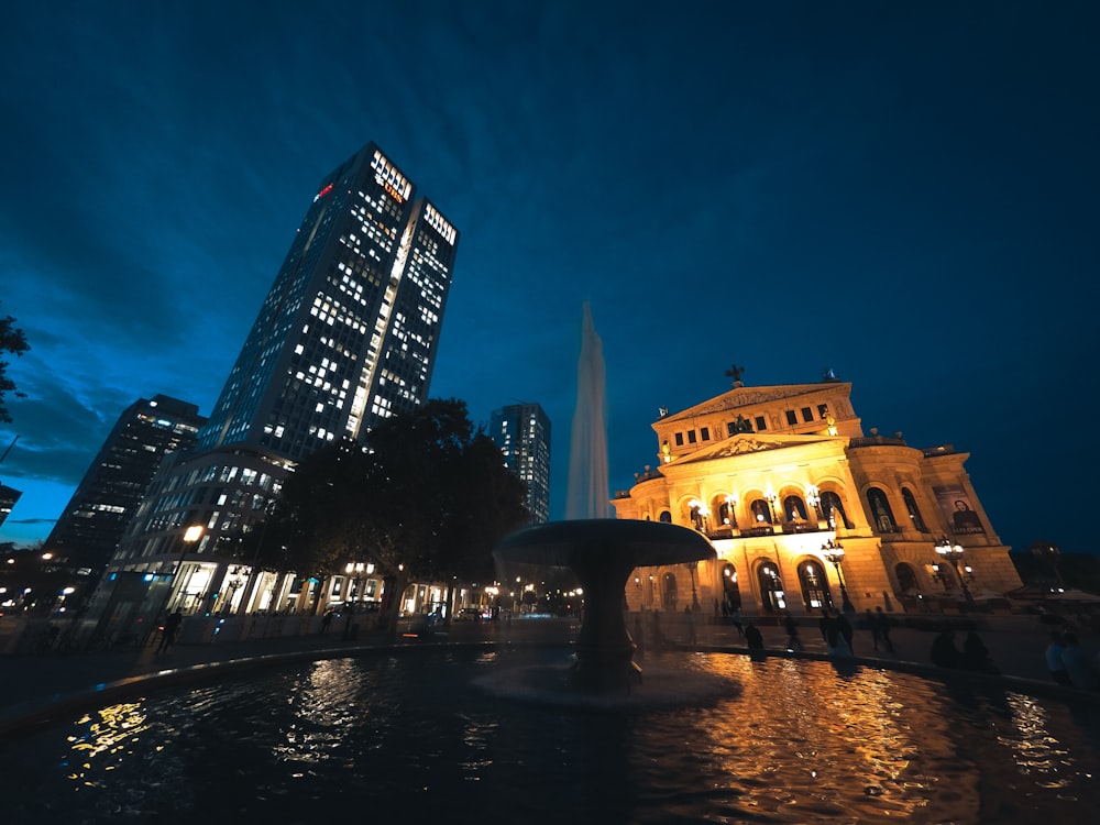 brown concrete building near water fountain during night time