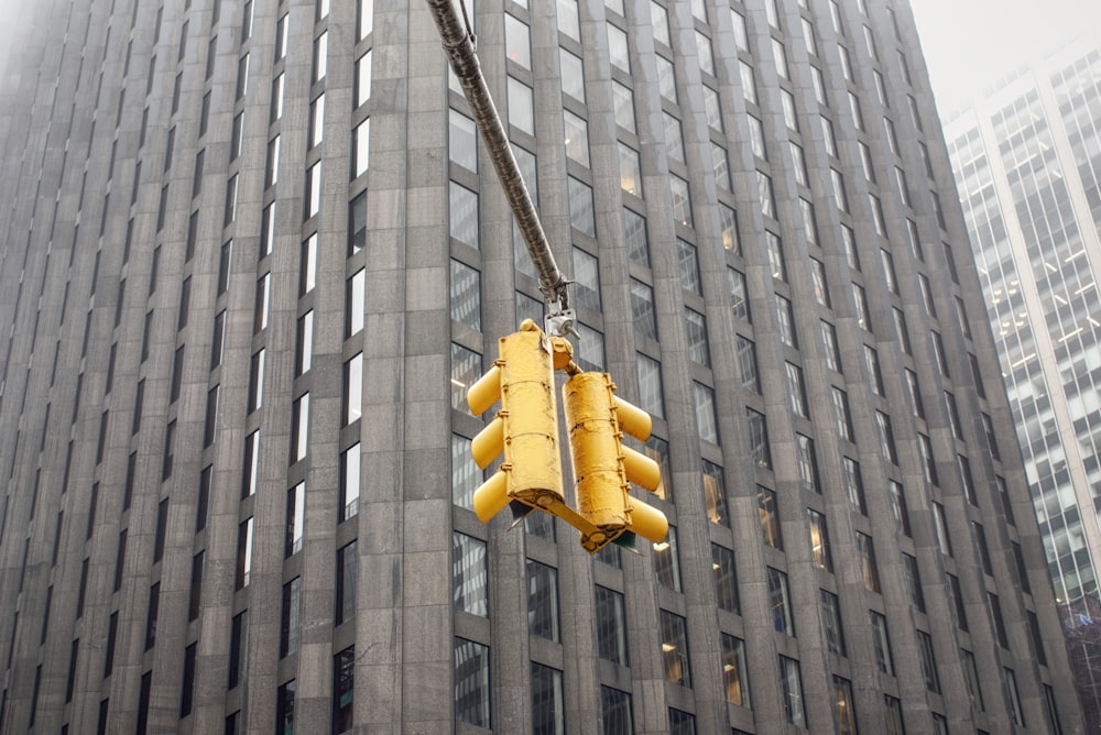 lampada a sospensione gialla su edificio in cemento grigio