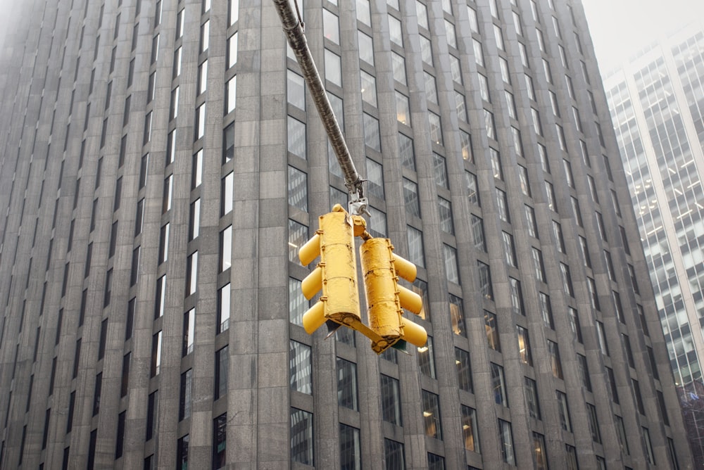 Lámpara colgante amarilla sobre edificio de hormigón gris