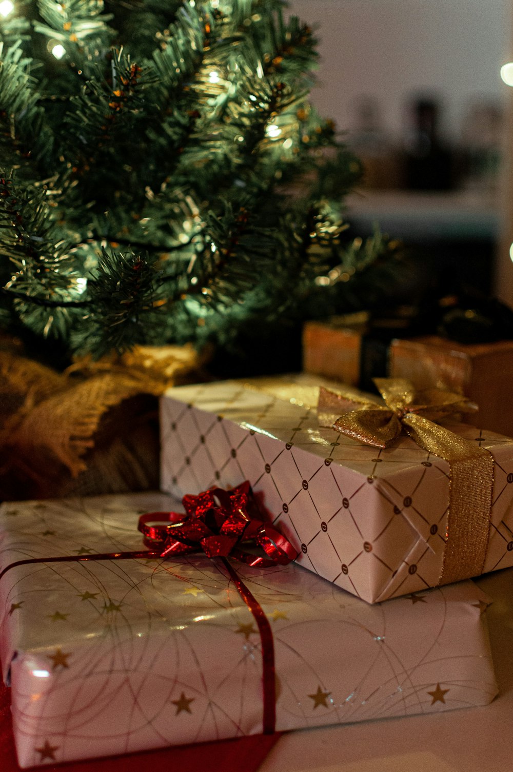 Cajas de regalo marrones y blancas junto al árbol de Navidad verde