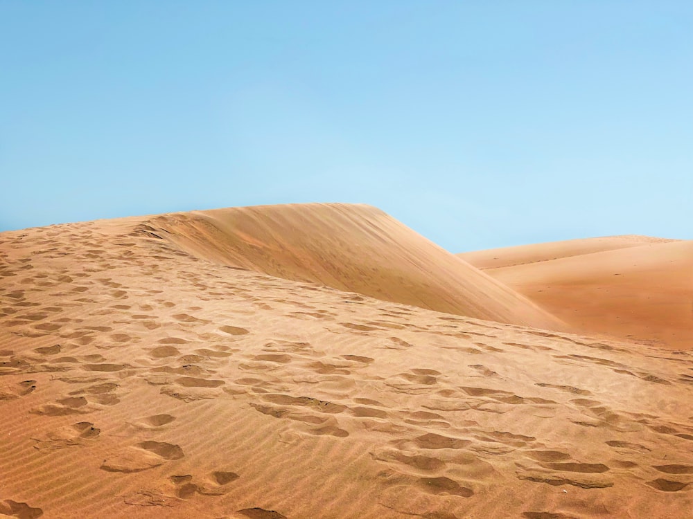 sable brun sous le ciel bleu pendant la journée