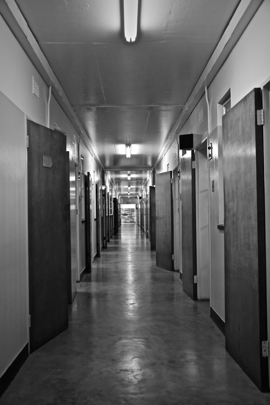 grayscale photo of hallway with doors