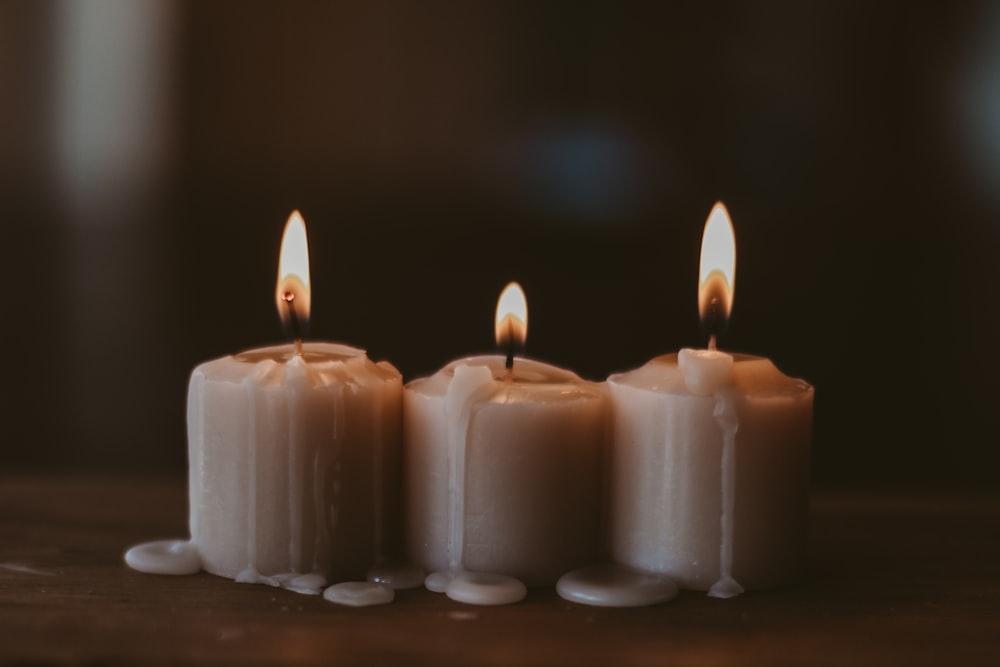 white candles on black surface