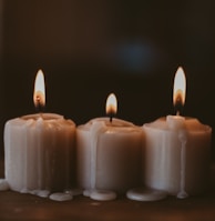 white candles on black surface