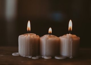 white candles on black surface